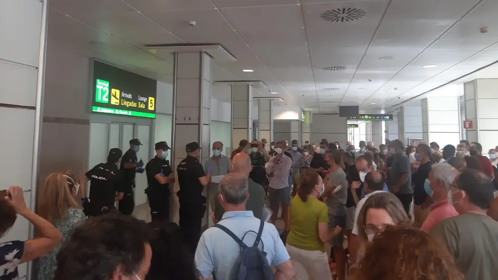 Los padres esperan en el aeropuerto de Madrid-Barajas la llegada de sus hijos desde Malta.