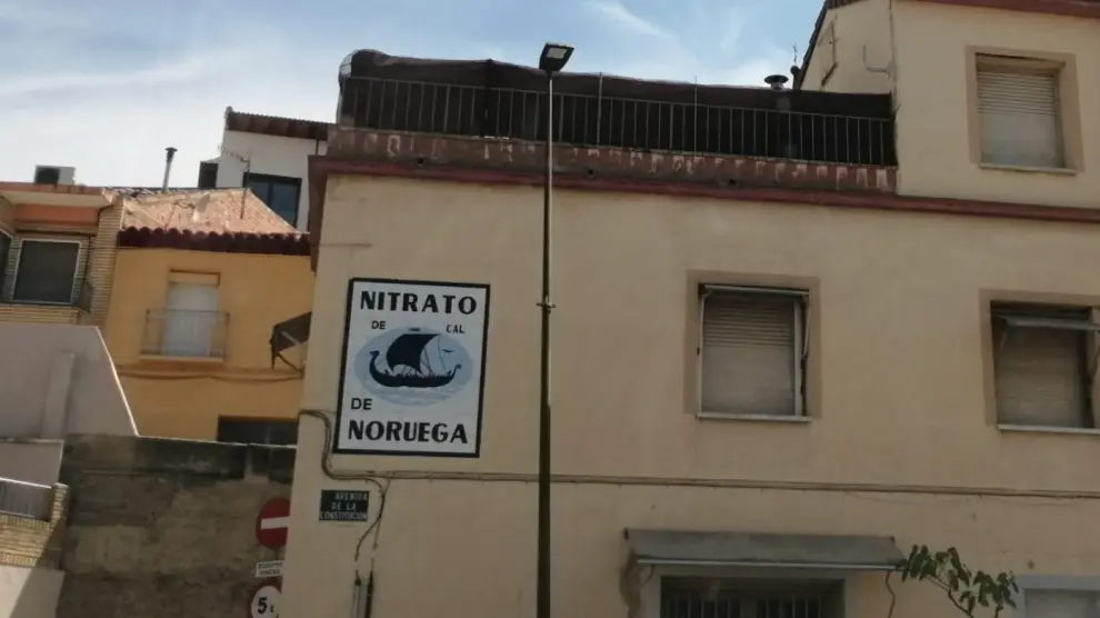 El cartel de 'Nitrato de Noruega' y la torre de Tauste al fondo.