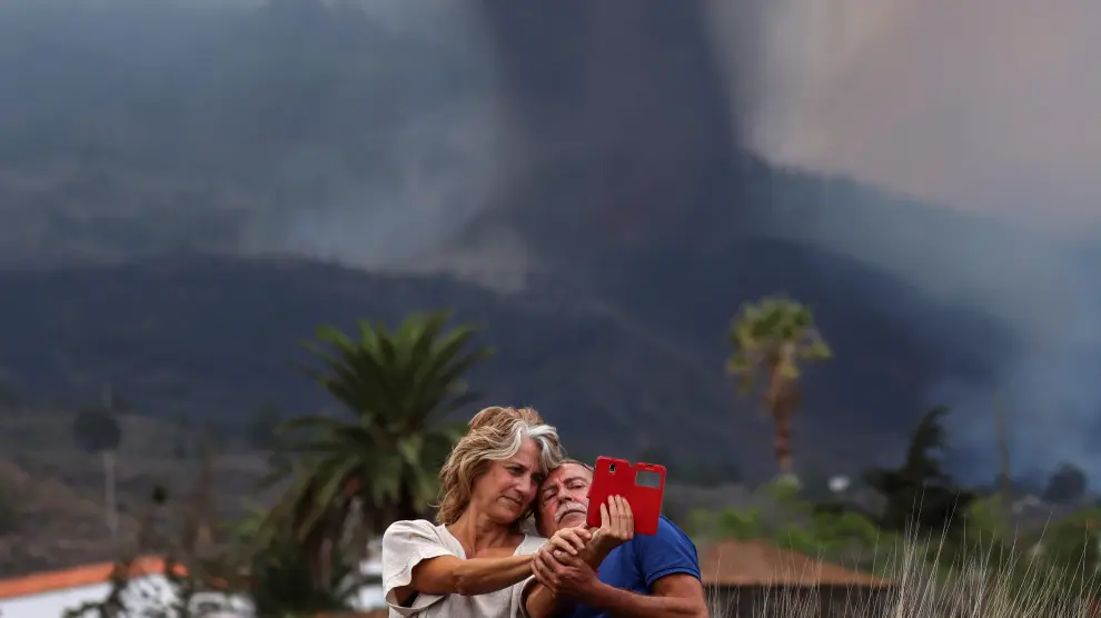 Una pareja se hace un selfi con el volcán de fondo