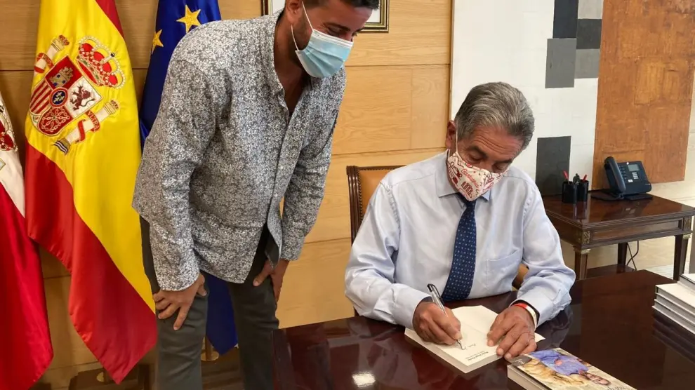 Miguel Ángel Revilla, firmando a Javier Pueyo uno de sus libros.
