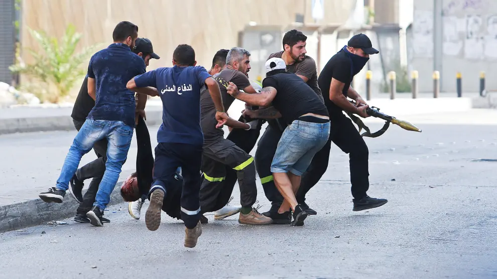 ATTENTION EDITORS - SENSITIVE MATERIAL. THIS IMAGE MAY OFFEND OR DISTURB Men run to rescue a person shot while preparing to fire a rocket-propelled grenade, during a gunfire in Beirut, Lebanon October 14, 2021. REUTERS/Aziz Taher[[[REUTERS VOCENTO]]] LEBANON-CRISIS/BLAST