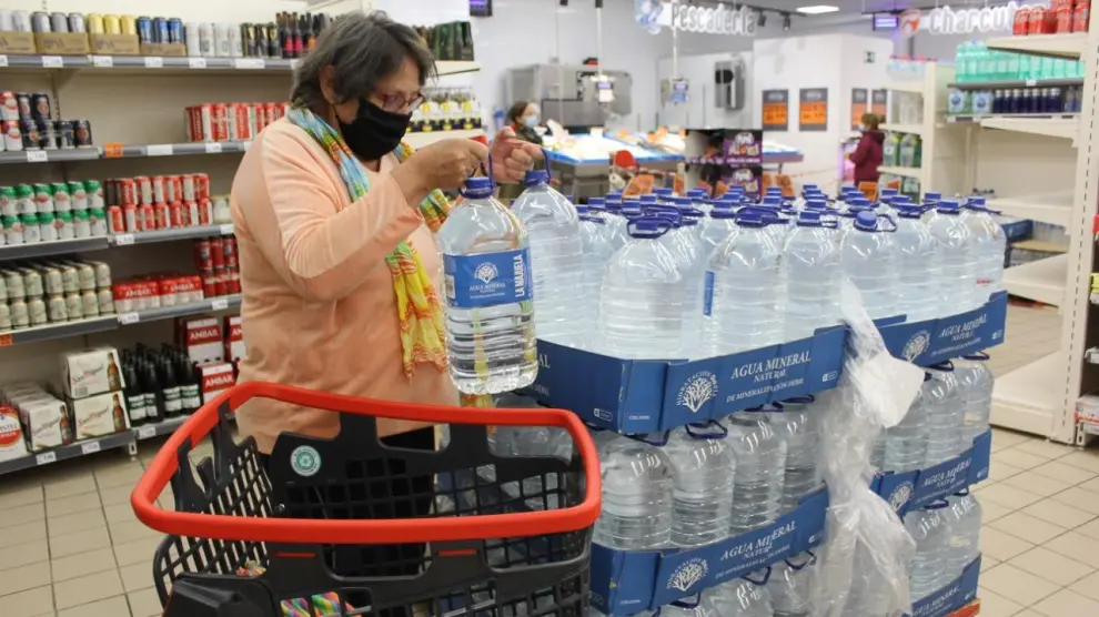 Cari Torres cargando su carro con agua embotellada en un supermercado de Sariñena.