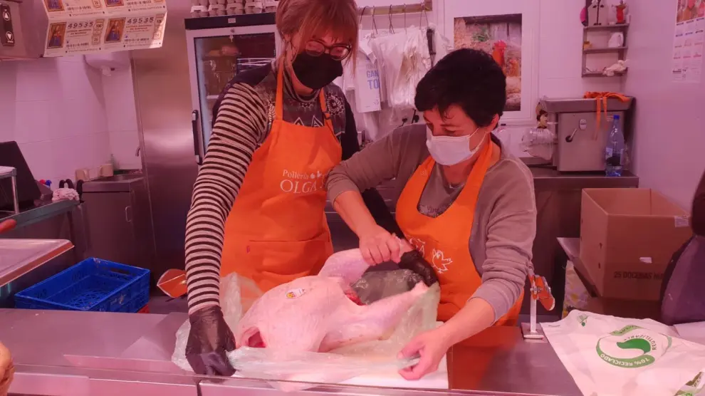 Yoli Naval y Rebeca Navarro envuelven un pavo de casi 8 kilos en su puesto en el Mercado Central.