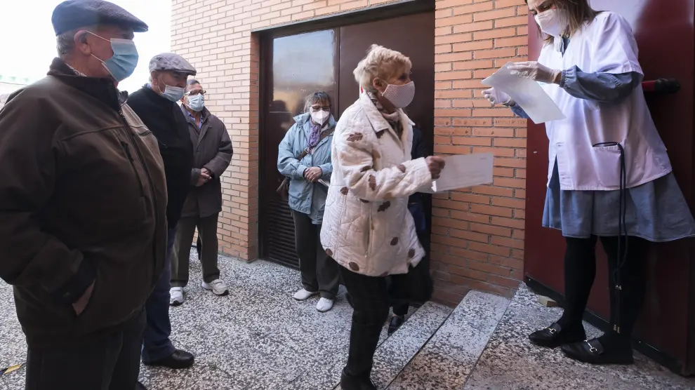 Varios pacientes mayores de 70 años acuden a ponerse la doble vacuna (de la gripe y la covid) al centro de salud de Garrapinillos, en Zaragoza.