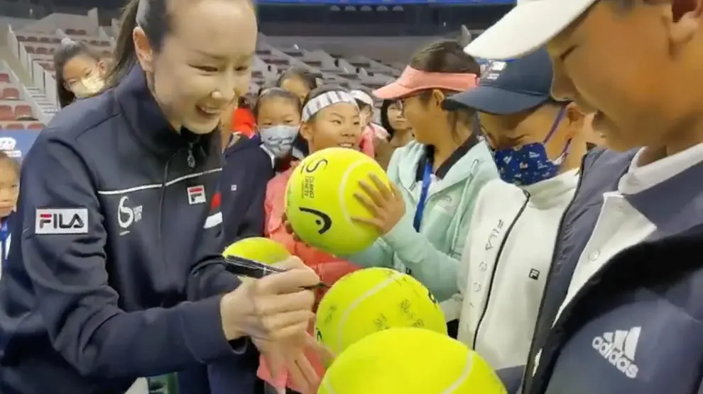 La tenista Peng Shuai firma autógrafos en un torneo infantil en China, tras su desaparición de la escena internacional.
