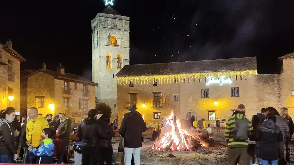 Público alrededor de la hoguera encendida en la plaza Mayor de Aínsa.