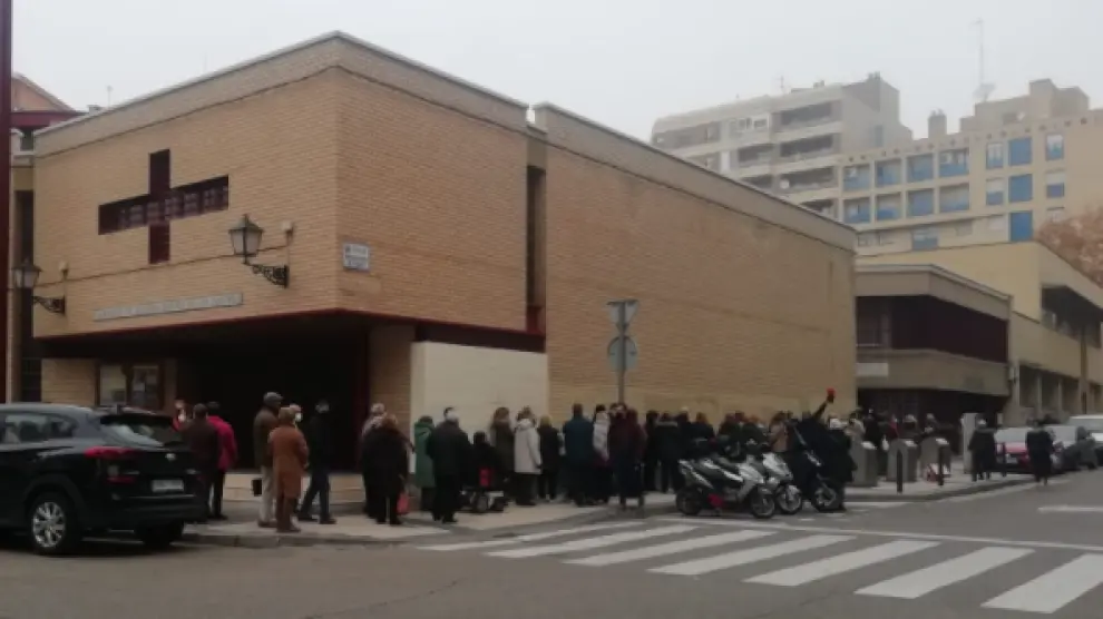 Numerosas personas guardan fila en el exterior de la parroquia donde se pone la tercera dosis, junto al centro de salud de San José Norte.