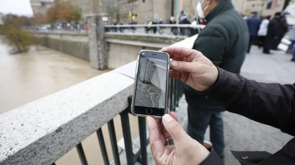 Un vecino de Zaragoza enseña en su teléfono móvil una fotografía que conserva de la anterior crecida extraordinaria, en 2015.