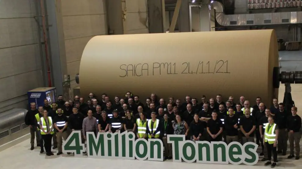 Trabajadores de la fábrica de papel de Saica en Mánchester posan delante de una gigantesca bobina para celebrar que en la factoría, que está en marcha desde enero de 2012, se han producido ya 4 millones de toneladas de papel.