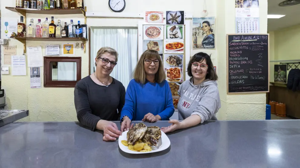 Ana Blasco, en el centro, con las cocineras del Amblas, mostrando una ración recién hecha de cabeza de ternasco.