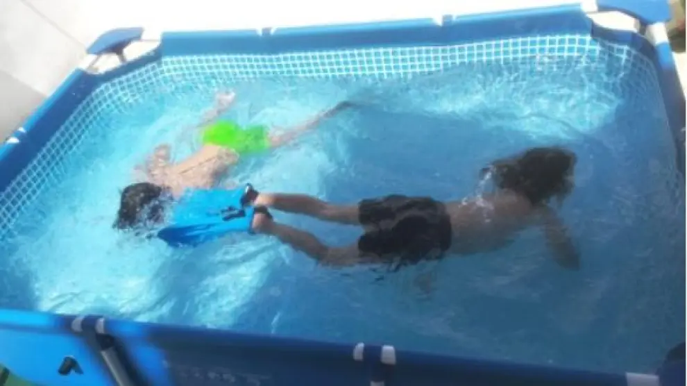 Dos menores en una piscina portátil, en una imagen de archivo.