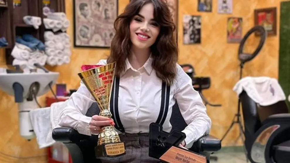 La joven Noelia Orga, con los dos premios obtenidos, en su barbería del barrio del Actur.