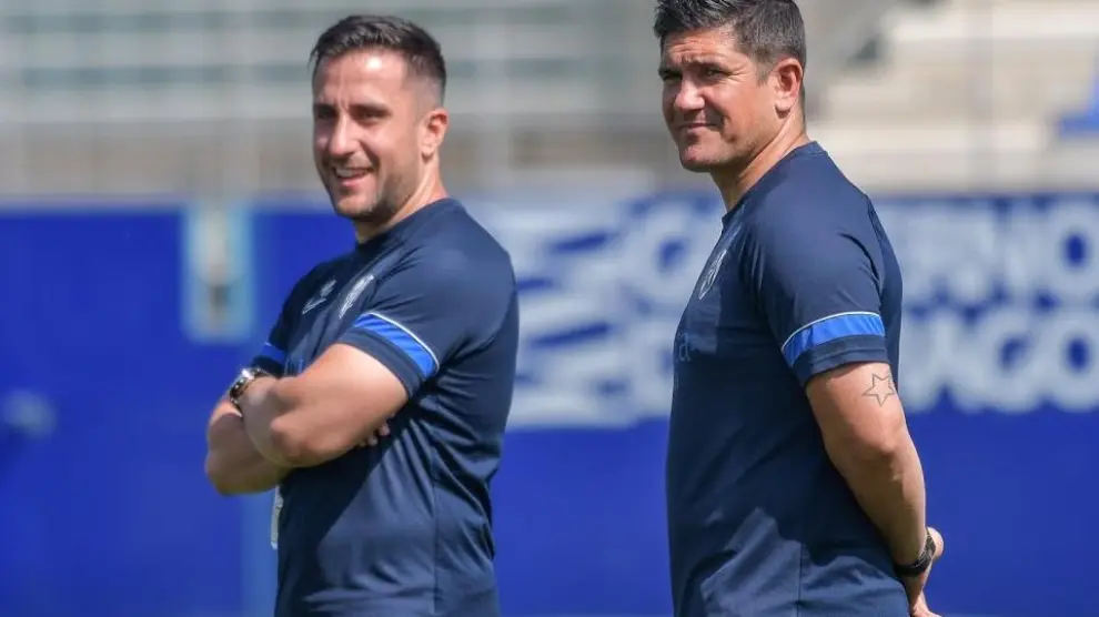 Xisco y su asistente Miguel Ángel Muñoz observan sonrientes un entrenamiento de la SD Huesca en El Alcoraz.