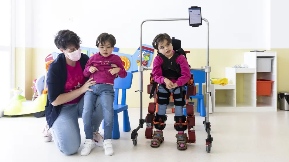 Las gemelas Sara y Noa Morfioli trabajan con el exoesqueleto pedriático Atlas 2030 de Atades, en Zaragoza.