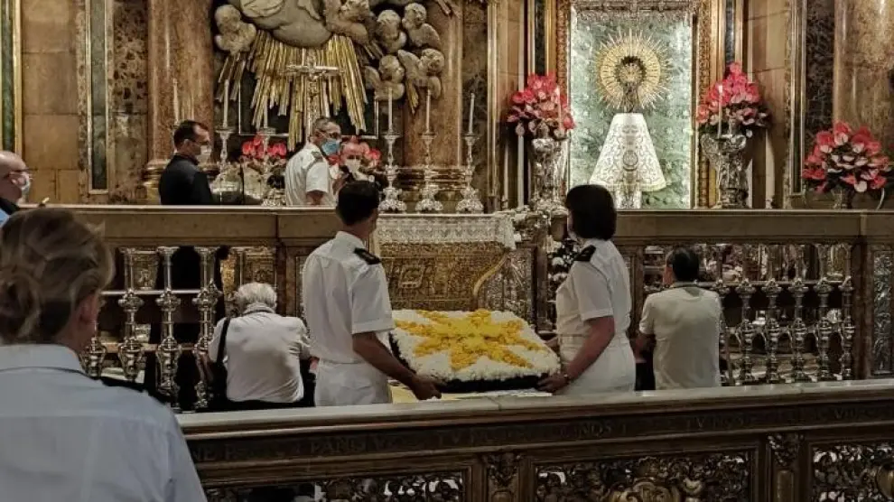 Dos militares llevan una ofrenda en la Basílica del Pilar por motivo de la festividad de Perpetuo Socorro del Hospital Militar.