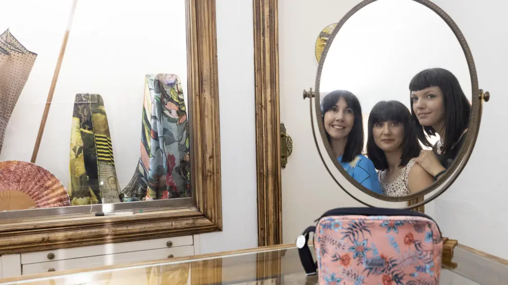 Las hermanas María, Patricia y Marta Redondo Briz reflejadas en un espejo de la tienda, en la calle de Jerónimo Blancas en Zaragoza.
