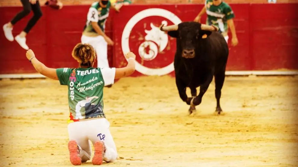 Amanda Monferrer aguanta de rodillas para hacer un quiebro a un toro.