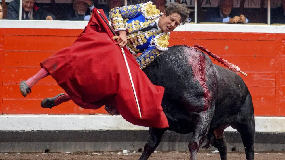 Cogida al diestro Roca Rey con el primero de los de su lote durante la corrida de la Feria de Bilbao celebrada este jueves en la plaza toros de Vistalegre.