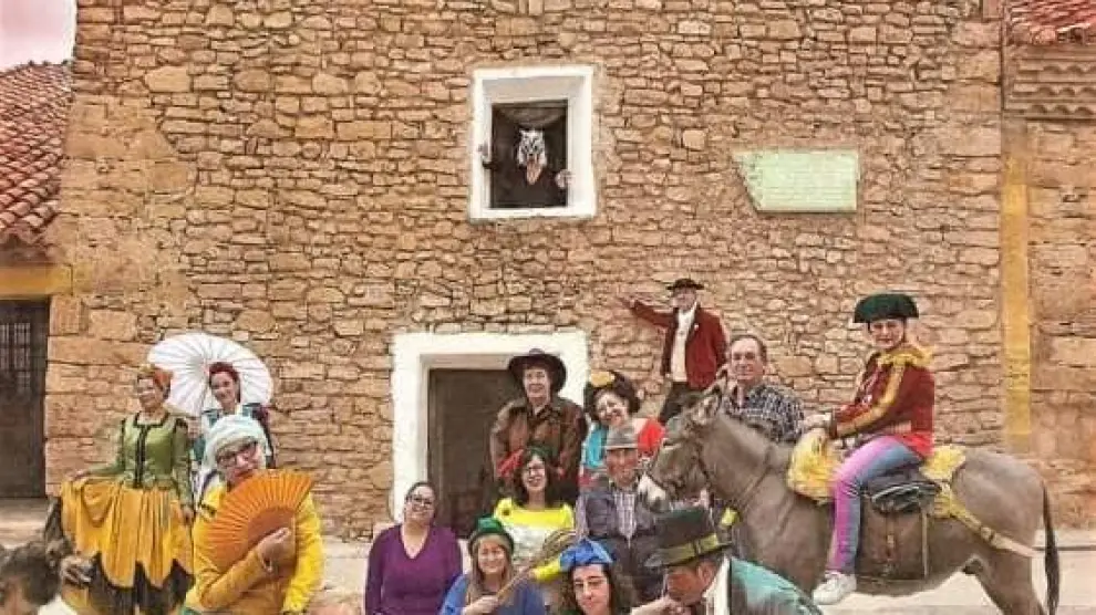 Foto de Ouka Lele con los vecinos de Fuendetodos y sus trajes delante de la casa de Goya.