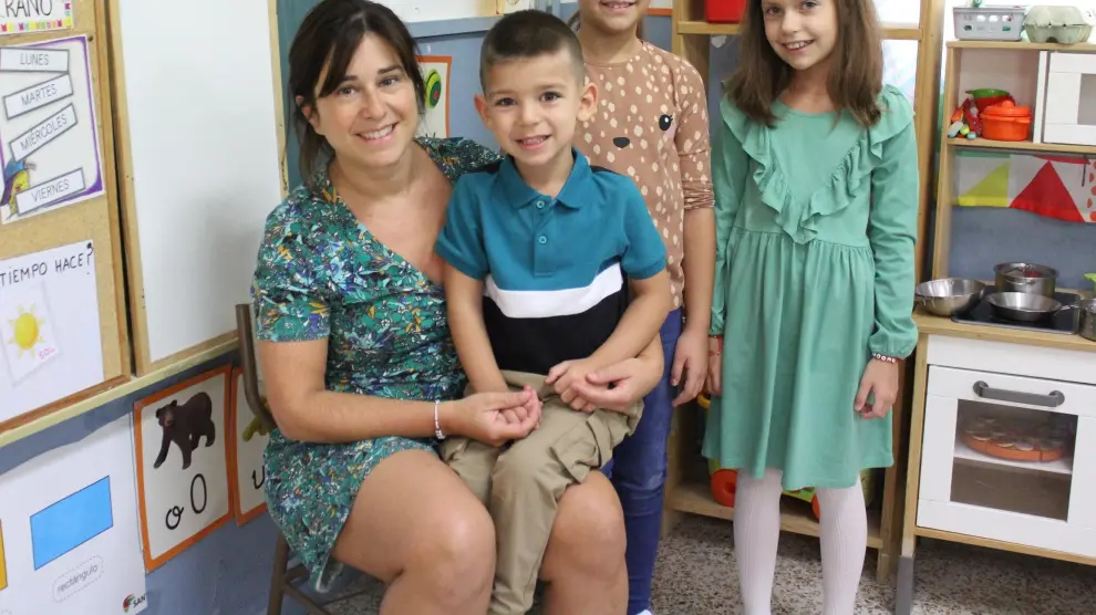 Davinia Portolés, con tres de los cinco alumnos de la escuela de Albalatillo.