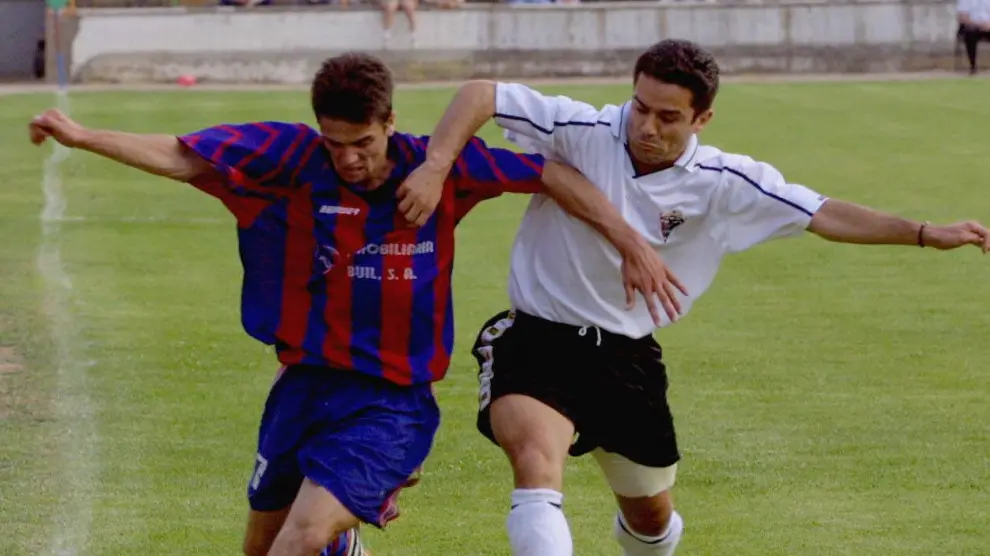 Nacho Novo, del Huesca, progresa con el balón marcado por un jugador del Mirandés en la victoria que dio el ascenso a 2ªB a los azulgranas en 2001