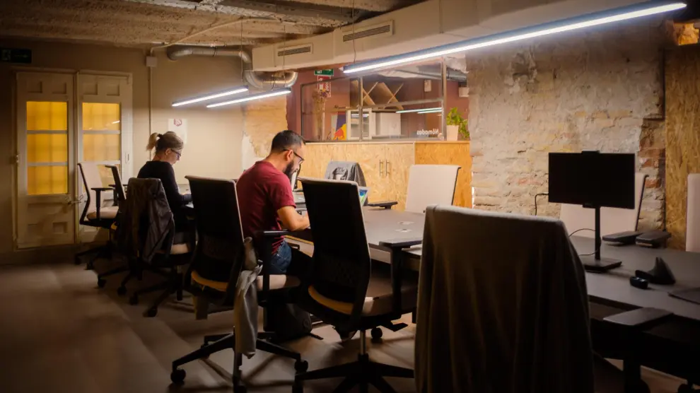 Dos personas trabajando en el centro de 'coworking' Impact Hub en Zaragoza.