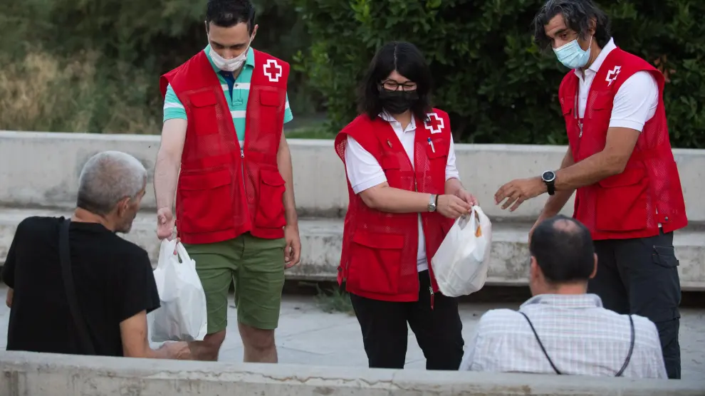 Un equipo de Cruz Roja atiende a dos transeúntes este pasado agosto, en plena ola de calor
