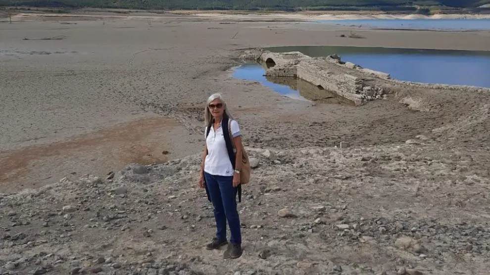 Ana Arbués, nacida en Tiermas, ante el puente de la carretera que oculta el pantano de Yesa, pero la sequía lo ha destapado.