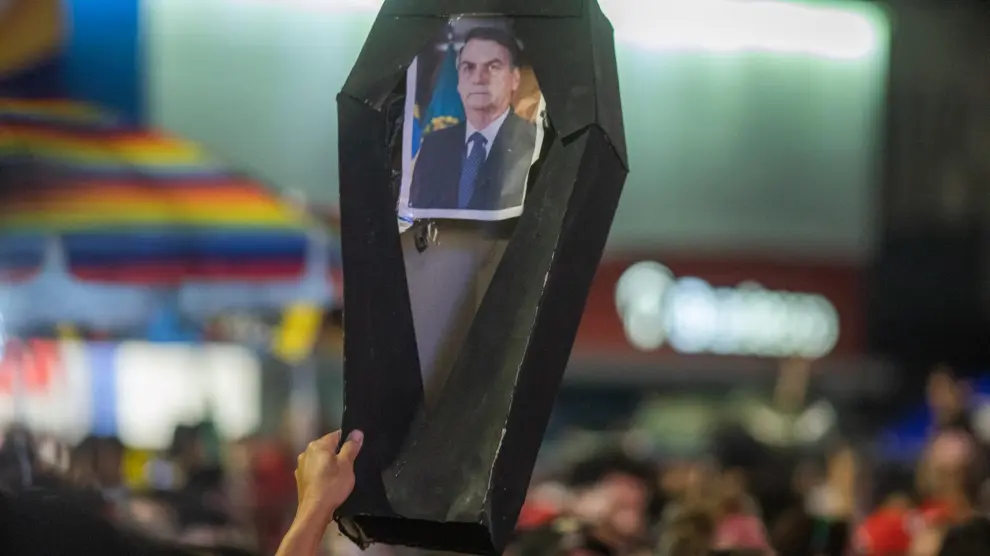 Un partidario de Lula da Silva sostiene un ataúd de cartón con una foto de Bolsonaro, el domingo en Sau Paulo.