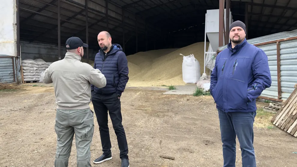 El director comercial Vadyn Bondarenko,  (en el centro de la imagen) ante un granero con 1.500 toneladas de cebada.