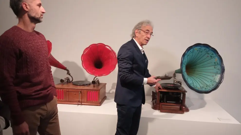 José Luis Mur, a la derecha, enseñando el funcionamiento de un gramófono que funcionaba con alcohol.