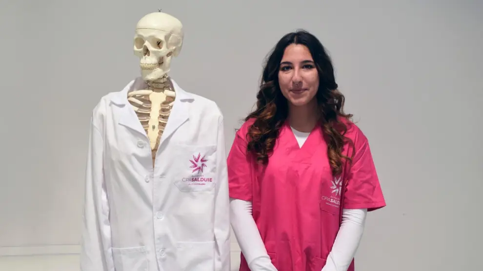 Celia Muñoz junto a un esqueleto, con el que practican durante las clases de auxiliar de enfermería.