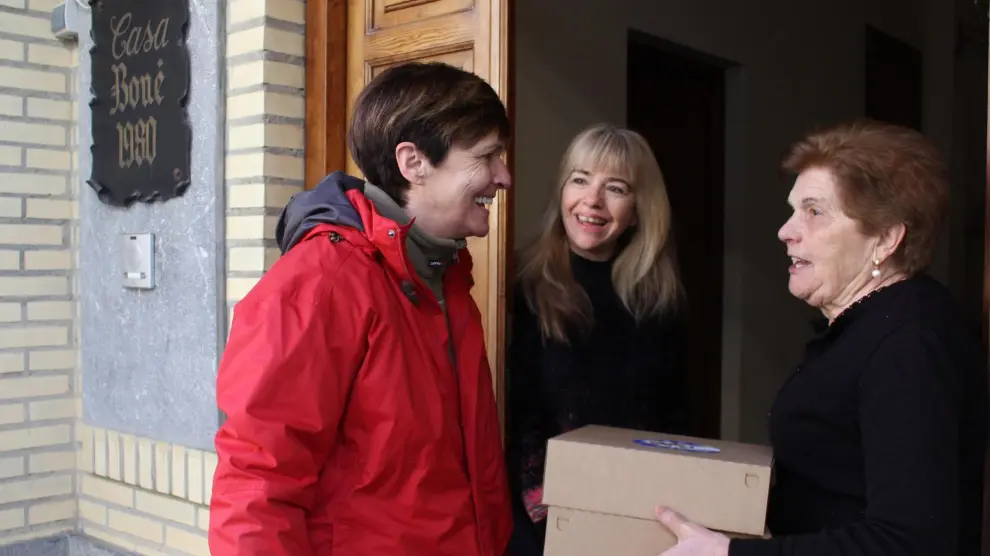 A la izquierda, la alcaldesa de Robres, Olga Brosed, repartiendo uno de los 250 roscones.