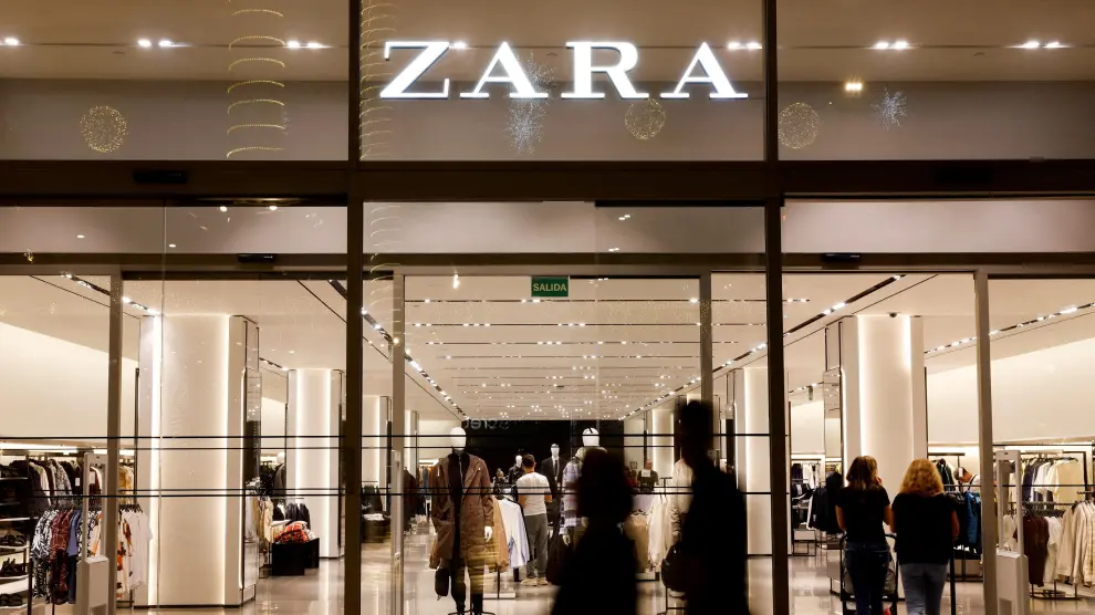 Los compradores pasan frente a una tienda de ropa Zara, parte del grupo español Inditex.
