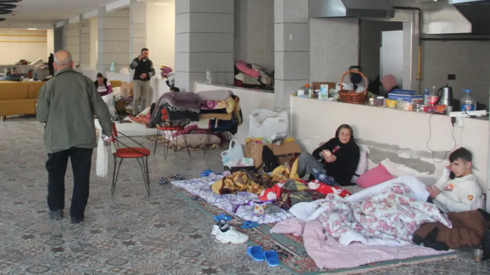 Supervivientes del terremoto en Iskenderun, Turquía, en el centro donde el equipo START español levanta un hospital de campaña para atender a las víctimas del terremoto