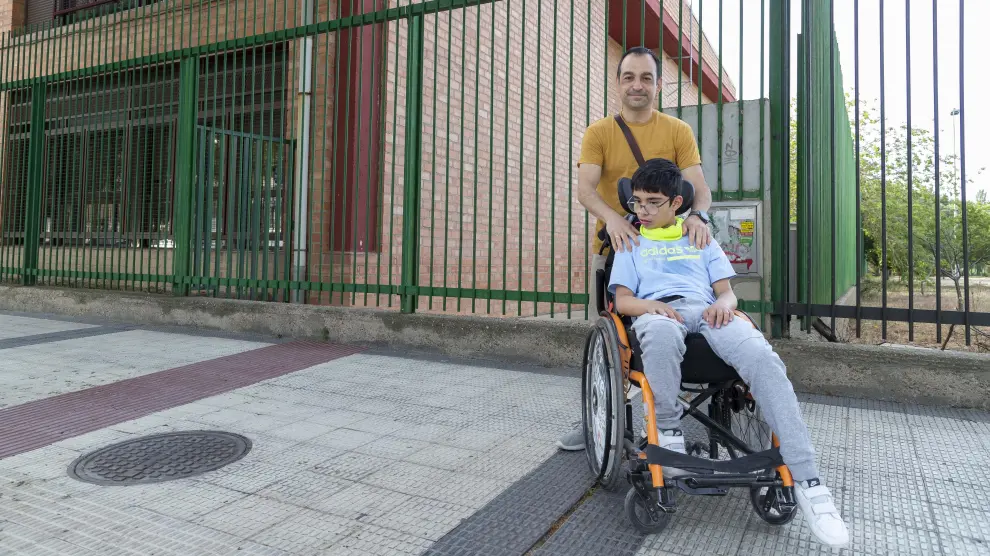 David García Martínez y su hijo Mario, de 12 años, a las puertas del colegio público de Educación Especial Ángel Riviere de Zaragoza.