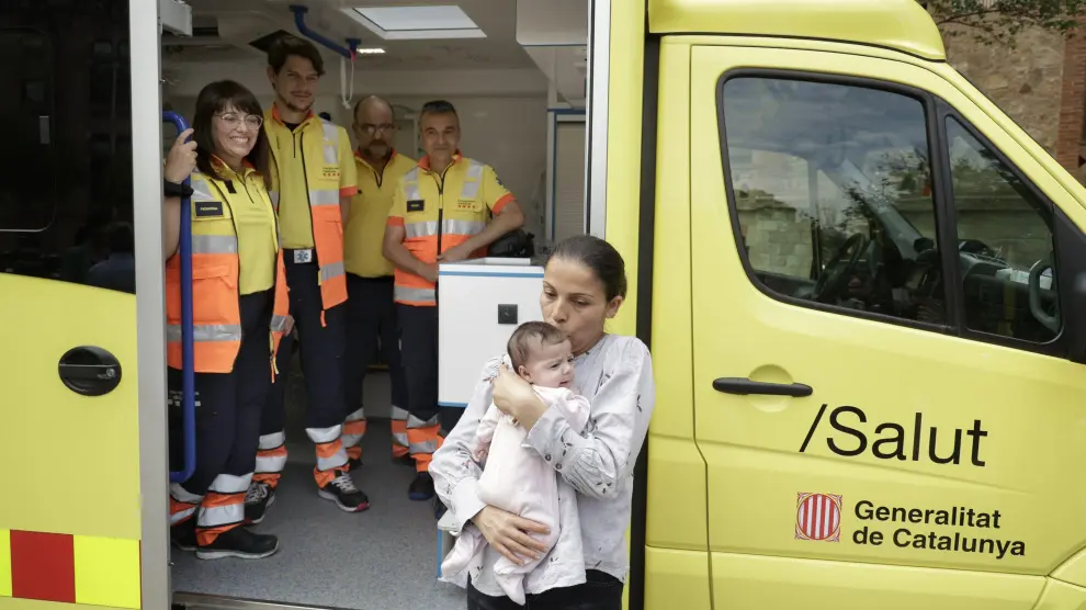 Radia Bakkari sostiene a su hija Aisha junto al equipo médico de la ambulancia que la trasladó de Tarragona a Barcelona.
