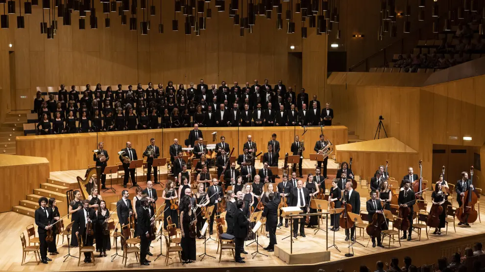 El coro Amici Musicae, arriba, y la Orquesta Reino de Aragón, durante el recital de este viernes en el Auditorio de Zaragoza