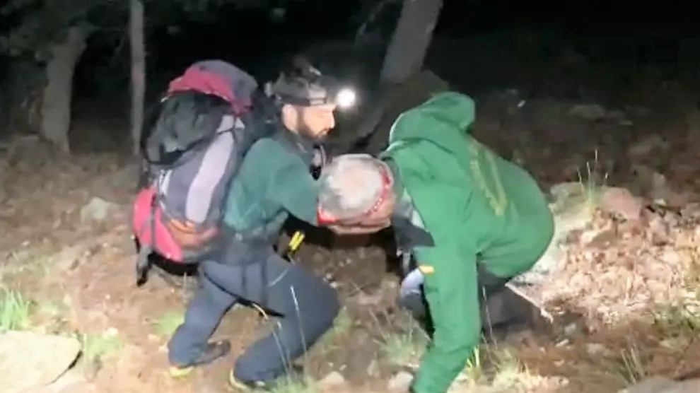 Un agente ayuda a uno de los montañeros que tropezó durante el descenso.