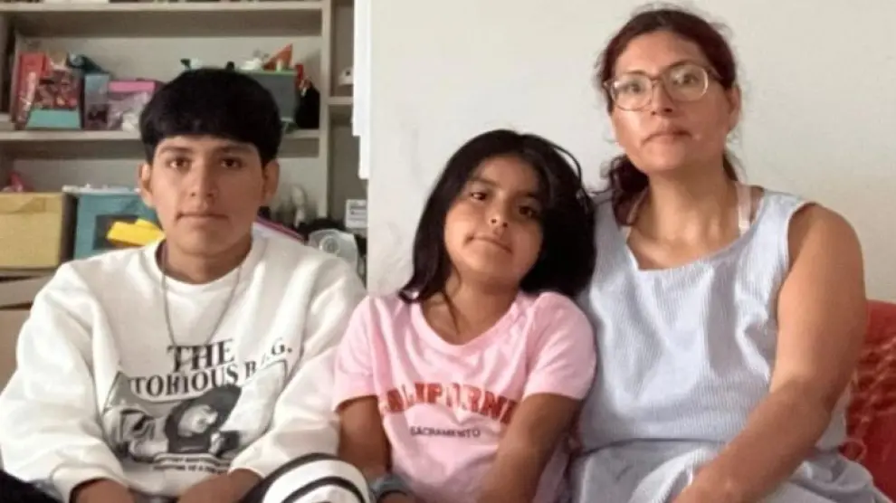 Verónica Velasco, con sus dos hijos, en el piso que comparte con otra familia monoparental.