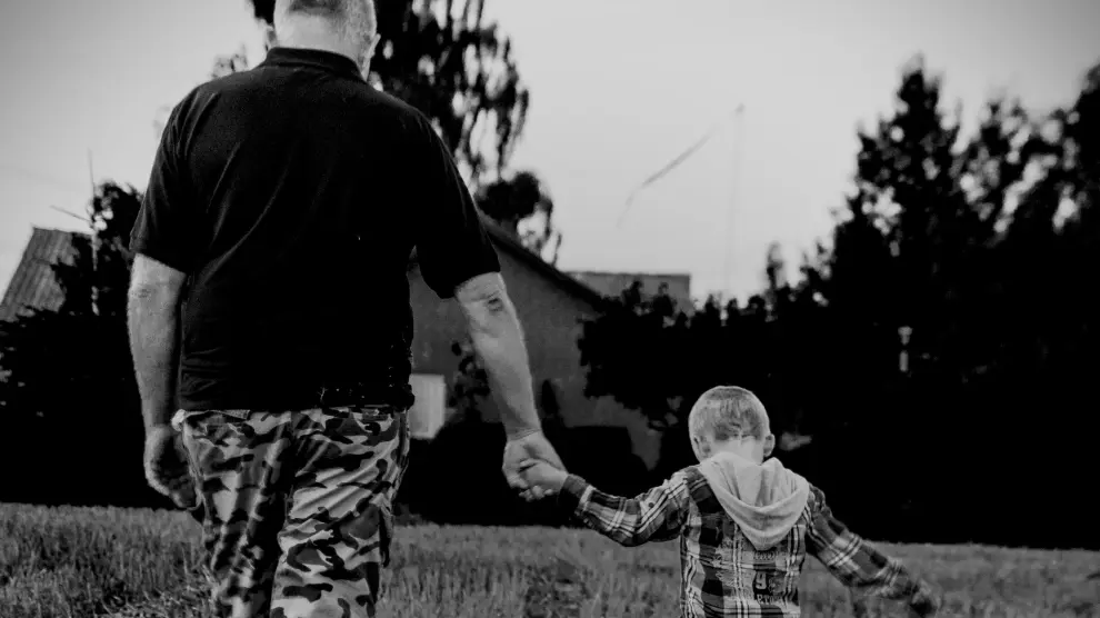 Un padre y un hijo caminan de la mano