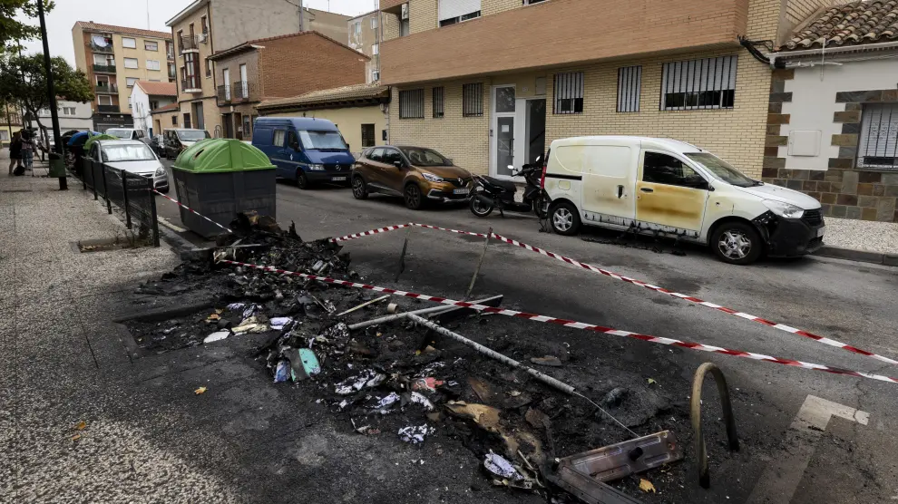 Restos de contenedores quemados en el barrio Oliver de Zaragoza.