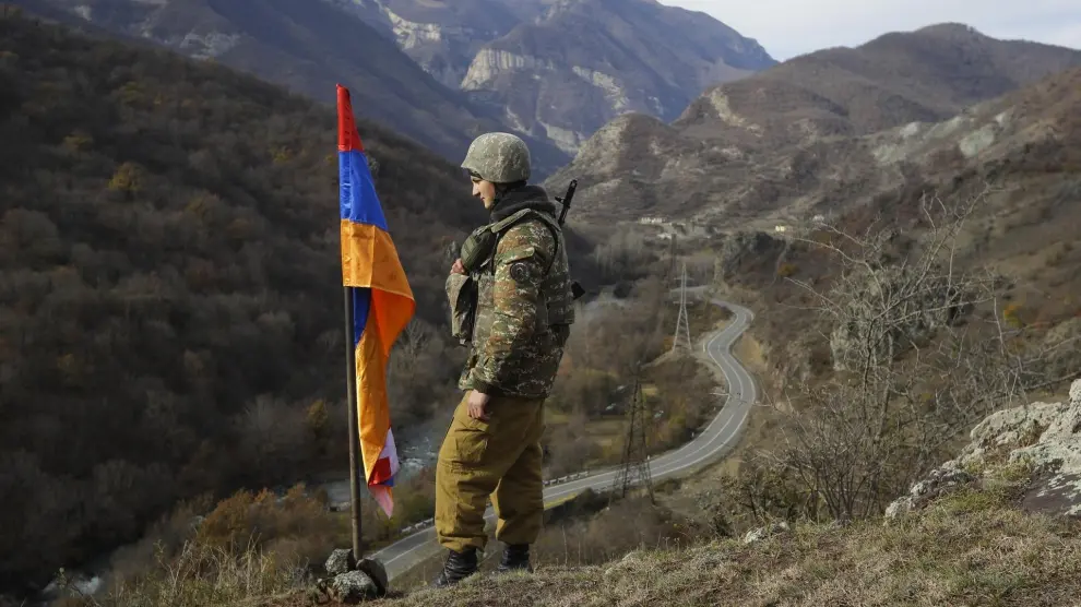 Un soldado de origen armenio, junto a una bandera de Nagorno Karabaj.