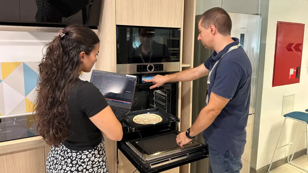 Mar Lahoz y Héctor Martínez, ingenieros de BSH, colocan una pizza para probar el horno.