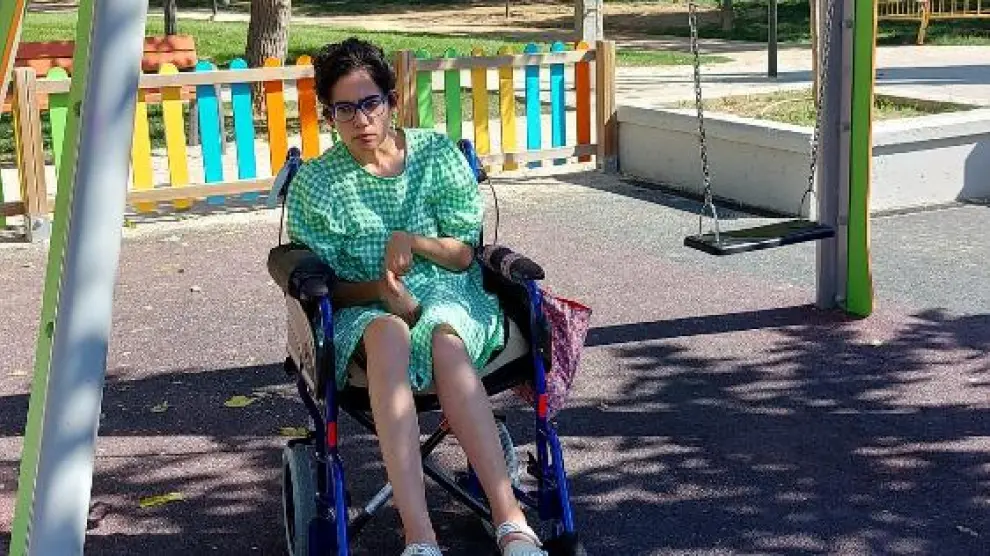 Judit Franco, que tiene una discapacidad intelectual y física severa, junto al espacio que ha dejado el columpio adaptado del parque Miraflores.