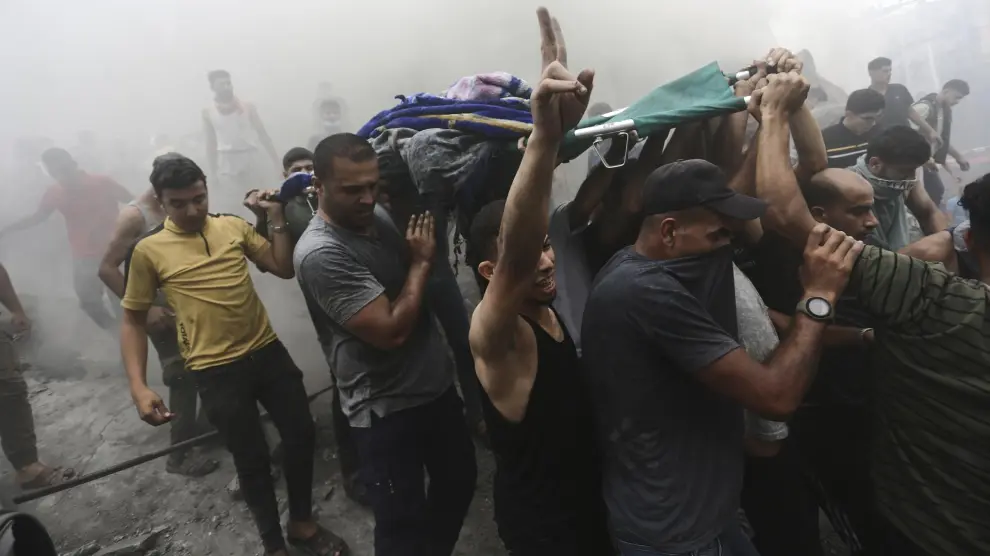 Palestinos retiran un cadáver de los escombros de un edificio después de un ataque aéreo israelí en el campo de refugiados de Jebaliya, en la Franja de Gaza.