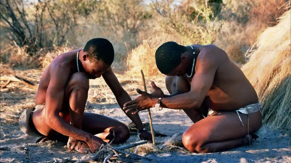 Hombres del pueblo san en Botsuana, mostrando cómo se hace fuego con una técnica tradicional.