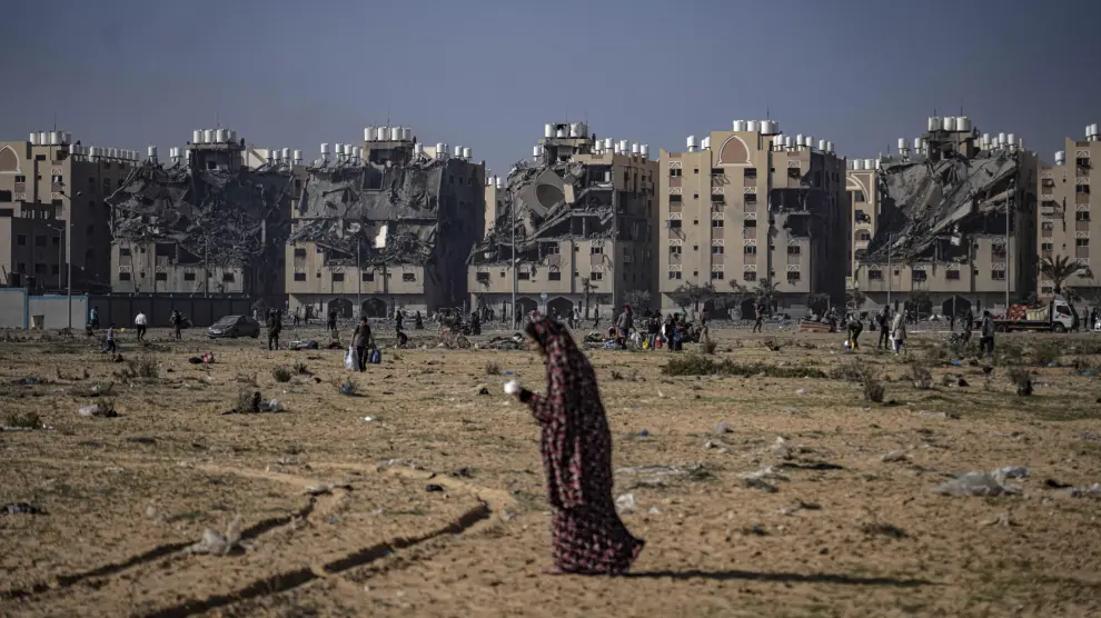 Una mujer camina en medio de una zona destruida por los bombardeos israelíes.