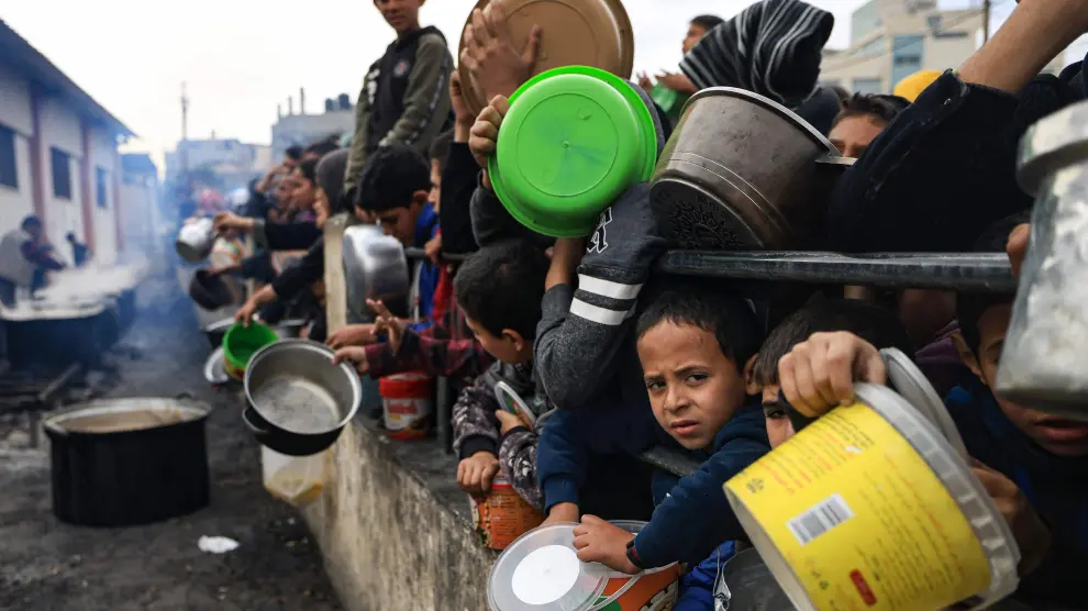Niños palestinos en la Franja de Gaza esperan a recibir alimentos, en una imagen de archivo.