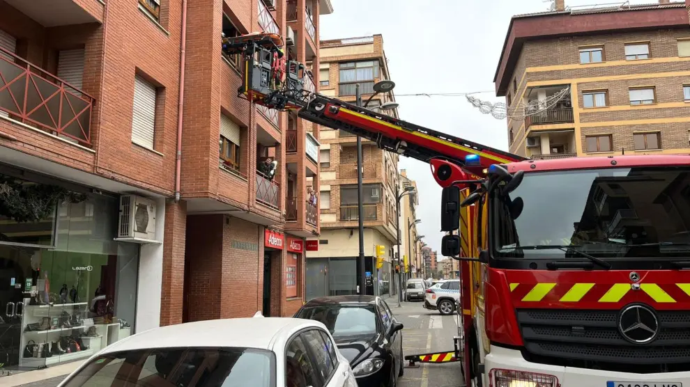 Los efectivos del Servicio de Prevención, Extinción de Incendios y Salvamento (SPEIS) de Huesca realizan una maniobra de rescate utilizando una autoescala para evacuar a una paciente por la ventana de su vivienda.